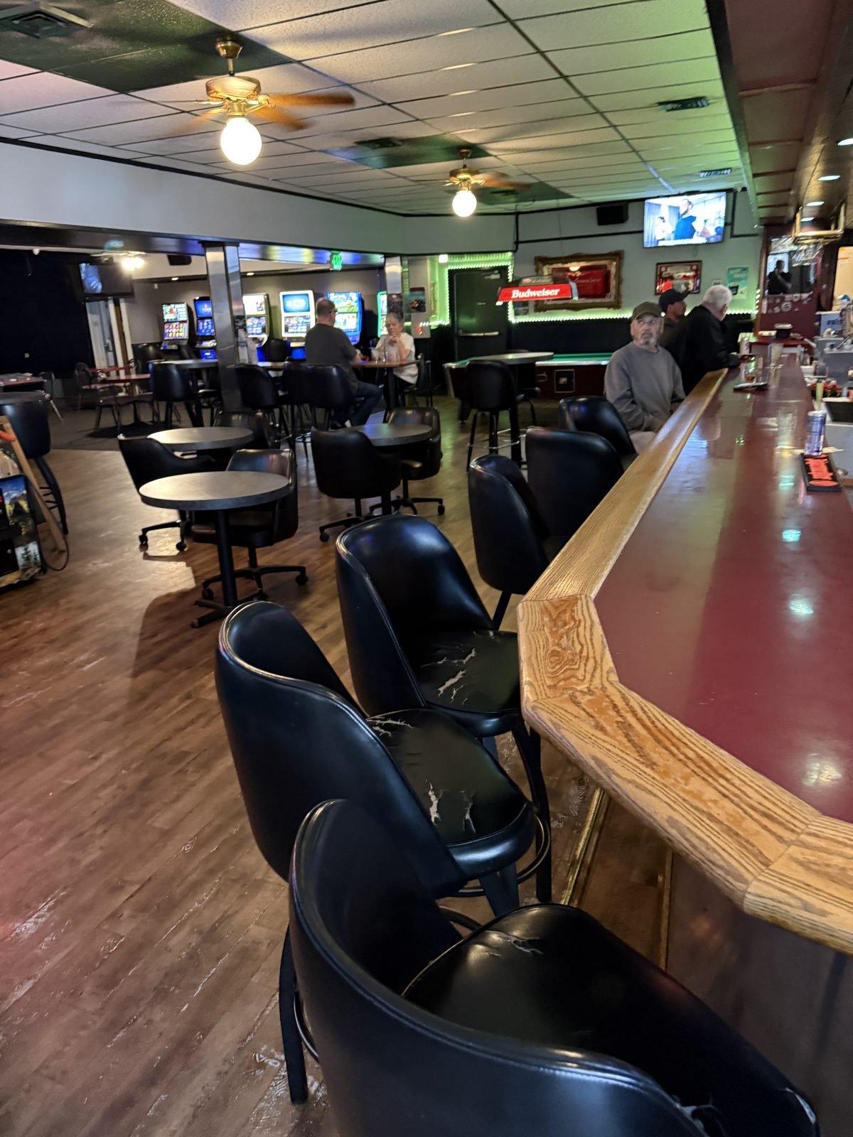 The lounge at M&M with tables, the bar and video lottery